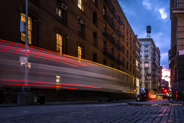 Quiet street in SOHO, New York, USA with light trails of cars passing