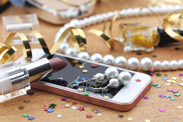 Cosmetics, phone and jewelry on a table after party