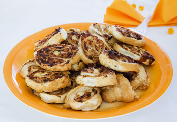 Preztels over orange plate, white cloth