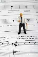 miniatura di insegnante di musica su pentagramma con note