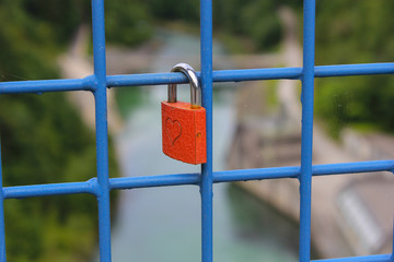 rotes Liebesschloss mit Herzen, auf einer Brücke