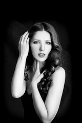 Portrait of beautiful woman in black dress with curly hair