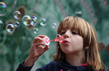 Bambina gioca con le bolle di sapone