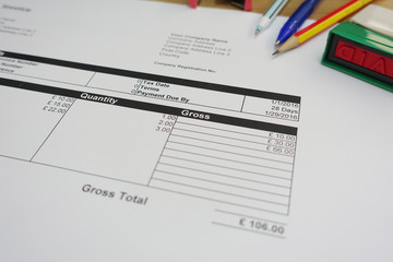       Person Hand Holding Rubber Stamp Over Red Paid Stamp On Invoice     