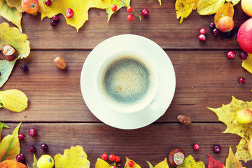close up of coffee cup on table with autumn leaves