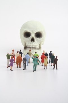 Figurines and skull on white background