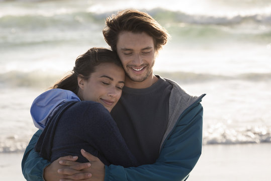 Happy romantic young couple embracing on beach