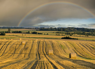 Tęcza nad polem po żniwach