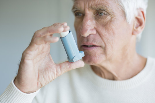 Close-up of a senior man using inhaler