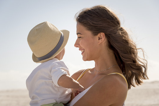 Happy mother with her little son enjoying on beach