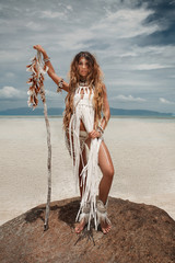 Attractive wild boho woman at beach. Native american style