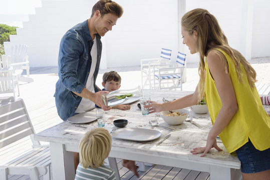 Young Family Enjoying Food At Porch