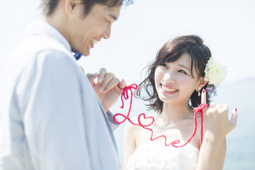 赤い糸で結ばれた新郎新婦