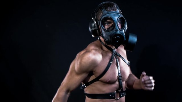 muscular man dancing wearing a gas mask