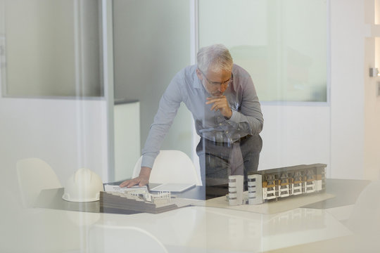 Design professional examining architectural model in an office