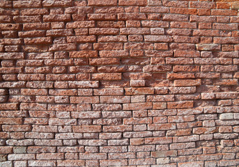 large red brick wall of old chipped in an old House