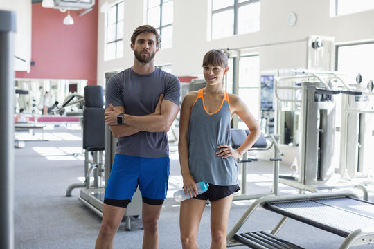 Portrait of young couple standing in fitness club