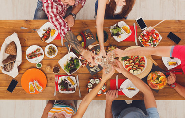 People say cheers clink glasses at festive table dinner party