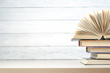 Open book, hardback books on wooden table. Education background. Back to school. Copy space for text.