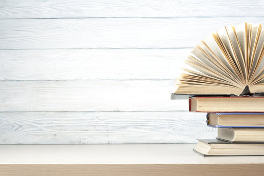 Open book, hardback books on wooden table. Education background. Back to school. Copy space for text.