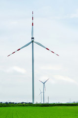 Fototapeta na wymiar Wind turbine in field. Group of wind turbine. A windfarm or wind park is a group of wind turbines in the same location used to produce electricity.