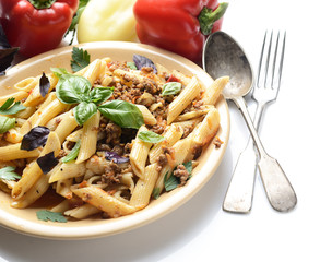 pasta with meat and basil on a plate on a white background