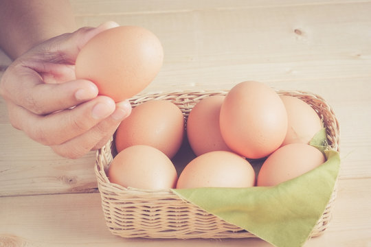hand holding egg on wooden background with filter effect retro v