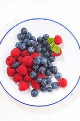 plate with berries on a white background, vertical closeup