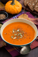 pumpkin soup in wooden bowl, closeup