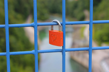 rotes Liebesschloss mit Herzen, auf einer Brücke