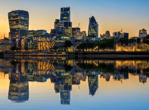 Illuminated London cityscape at sunset with reflection from river Thames