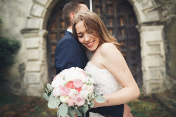 Happy wedding couple hugging and smiling each other on background old castle