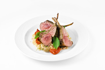 Rack of lamb with bulgur, dried tomatoes and lemon Moroccan on a plate on a white background