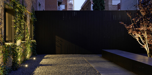 Exterior of building with foliage on the walls and dim lighting.