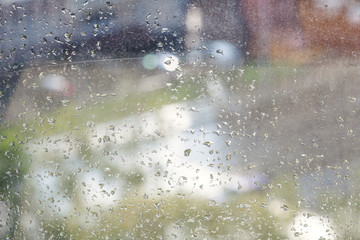 raindrops on windowpane and blurred urban street