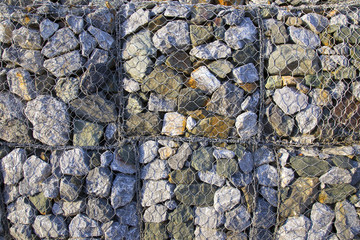 Wire Gabion Rock Fence. Metal Cage filled with rocks. Texture background of rock fence with cage.