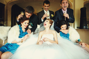 Groom and groomsmen attack girls sitting on the couch