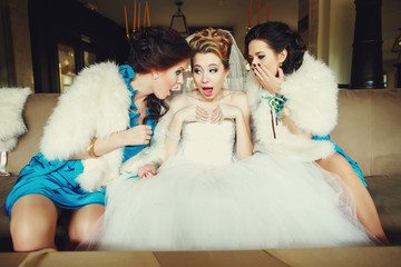 Funny bridesmaids look in a bride's corset sitting on the couch