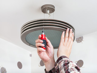 Electrician mounts round ceiling light