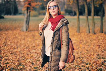 Beautiful girl student with a backpack, glasses, outdoors.