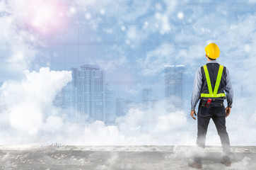 Double exposure of Engineer holding yellow helmet.