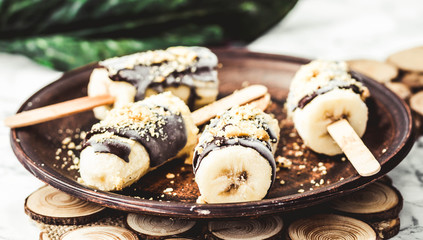Frozen bananas with chocolate and nuts, raw summer dessert