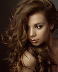 Naklejka premium Portrait of a young beautiful brunette girl with long hair 