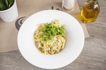 Pasta fettuccine alfredo with chicken, parmesan and parsley on w