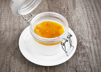 Layered dessert with fruits and cream cheese in glass jar