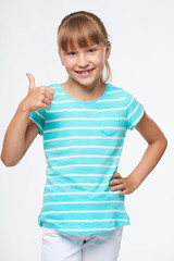 Smiling elementary school age girl showing thumb up