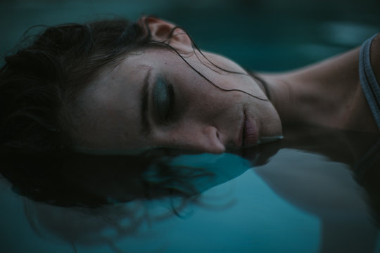 Sensual woman with make-up in water with eyes closed