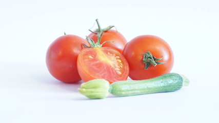 Крассные помидоры и цукини изолированы на белом фоне