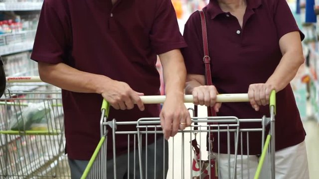 Asian Senior Couple Shopping At Supermarket With Cart