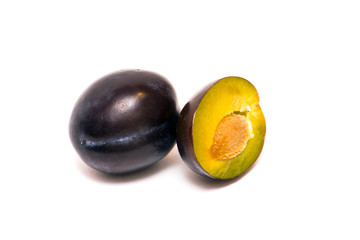whole plum and half a plum on a white background